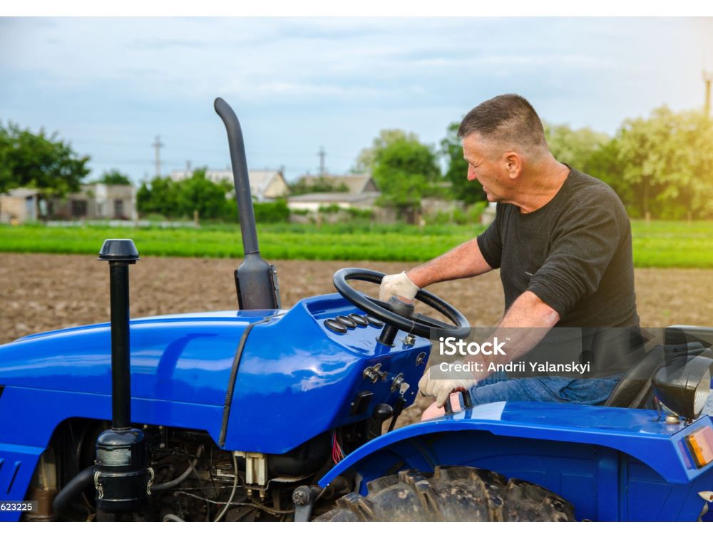 HOMEM OPERANDO TRATOR DE PEQUENO PORTE, DEMONSTRANDO QUE ATÉ PARA TRABALHOS MAIS SIMPLES O TRATOR É FUNDAMENTAL.